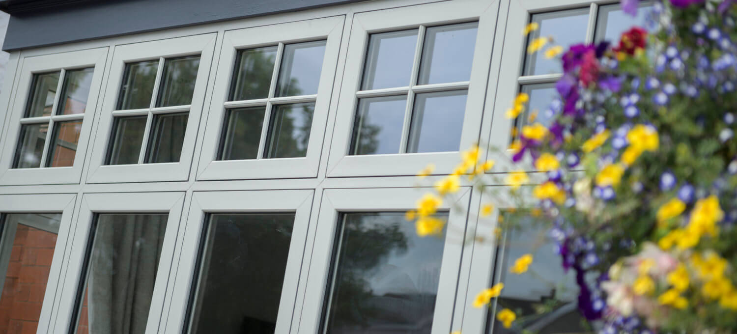white flush casement windows with flowers in the right corner