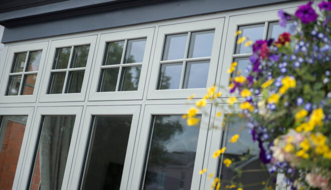 white flush casement windows with flowers in the right corner