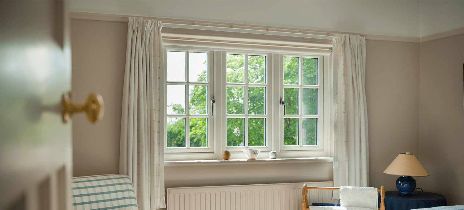 white upvc sculptured sash windows with cream curtains